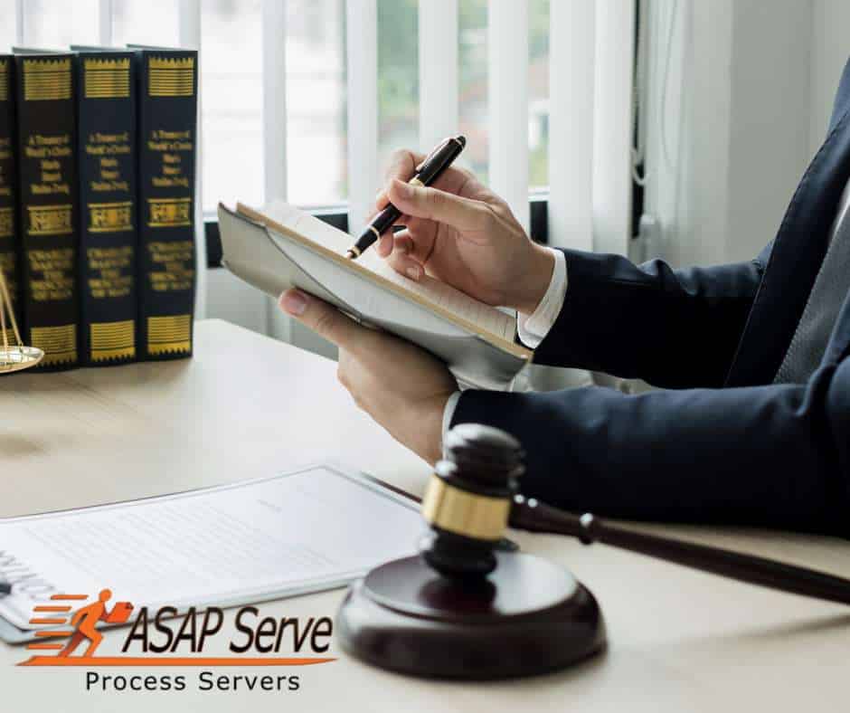Attorney reviewing legal documents and writing case notes beside a gavel while preparing an order of protection in Arizona.