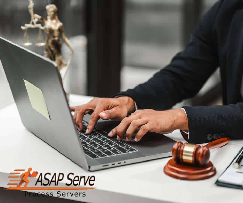 Man typing on a laptop beside a gavel and justice statue, symbolizing legal delays when a Process Server Fails