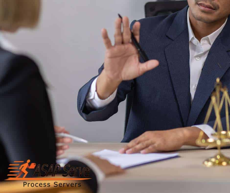 Process server discussing legal documents with a client at a desk.